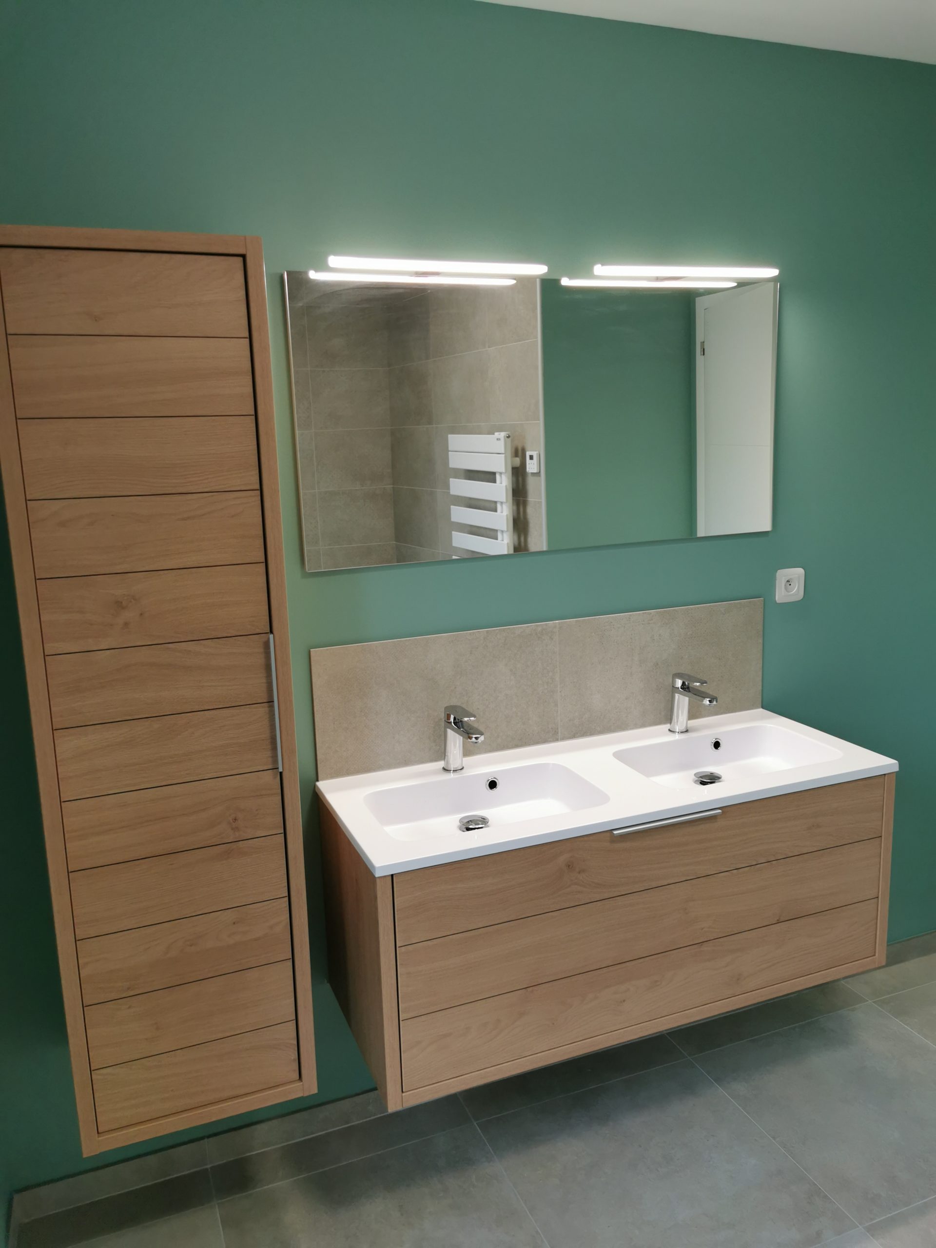Pose d’un meuble double vasque dans une salle de bains rénovée.