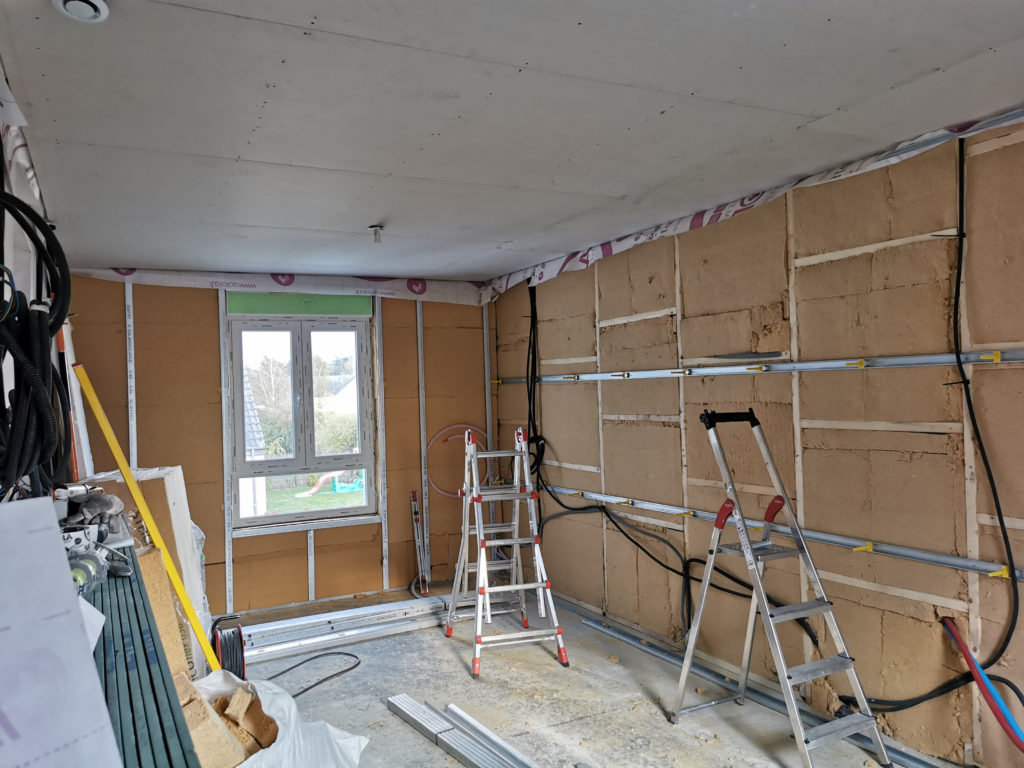 Installation de plaques de plâtre BA13 sur le plafond suite à une isolation complète.