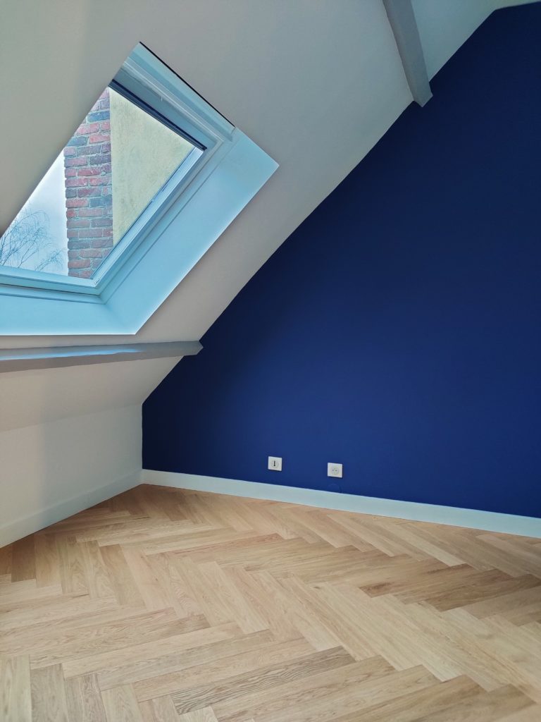 Réalisation de la peinture dans une chambre mansardée rénovée.