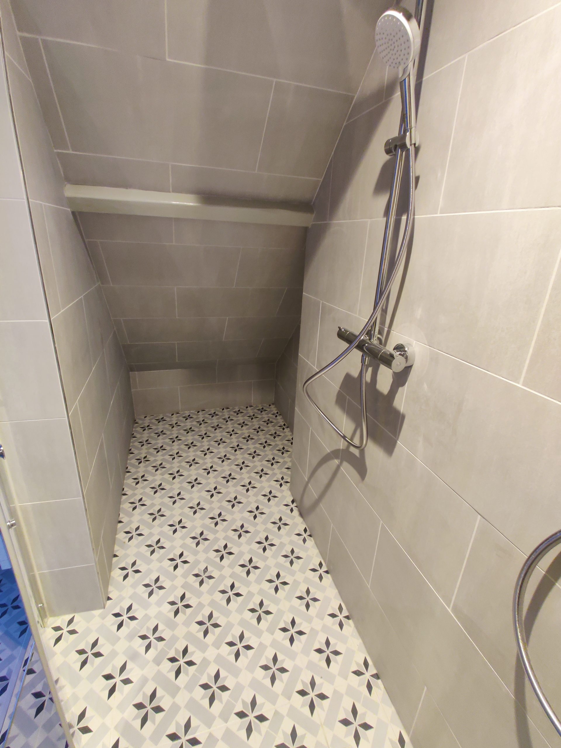 Installation d’un carrelage neuf avec grands carreaux muraux et crédence élégante au sol.