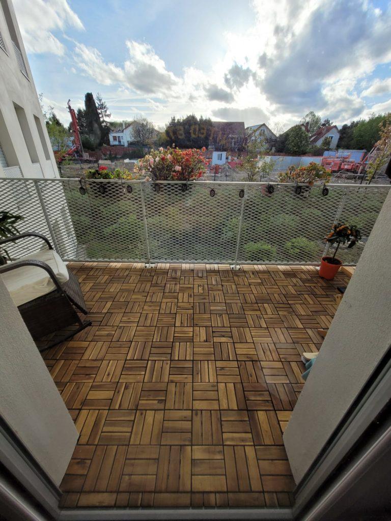Pose de dalles en bois pour le revêtement de sol d’une terrasse sur un balcon parisien.