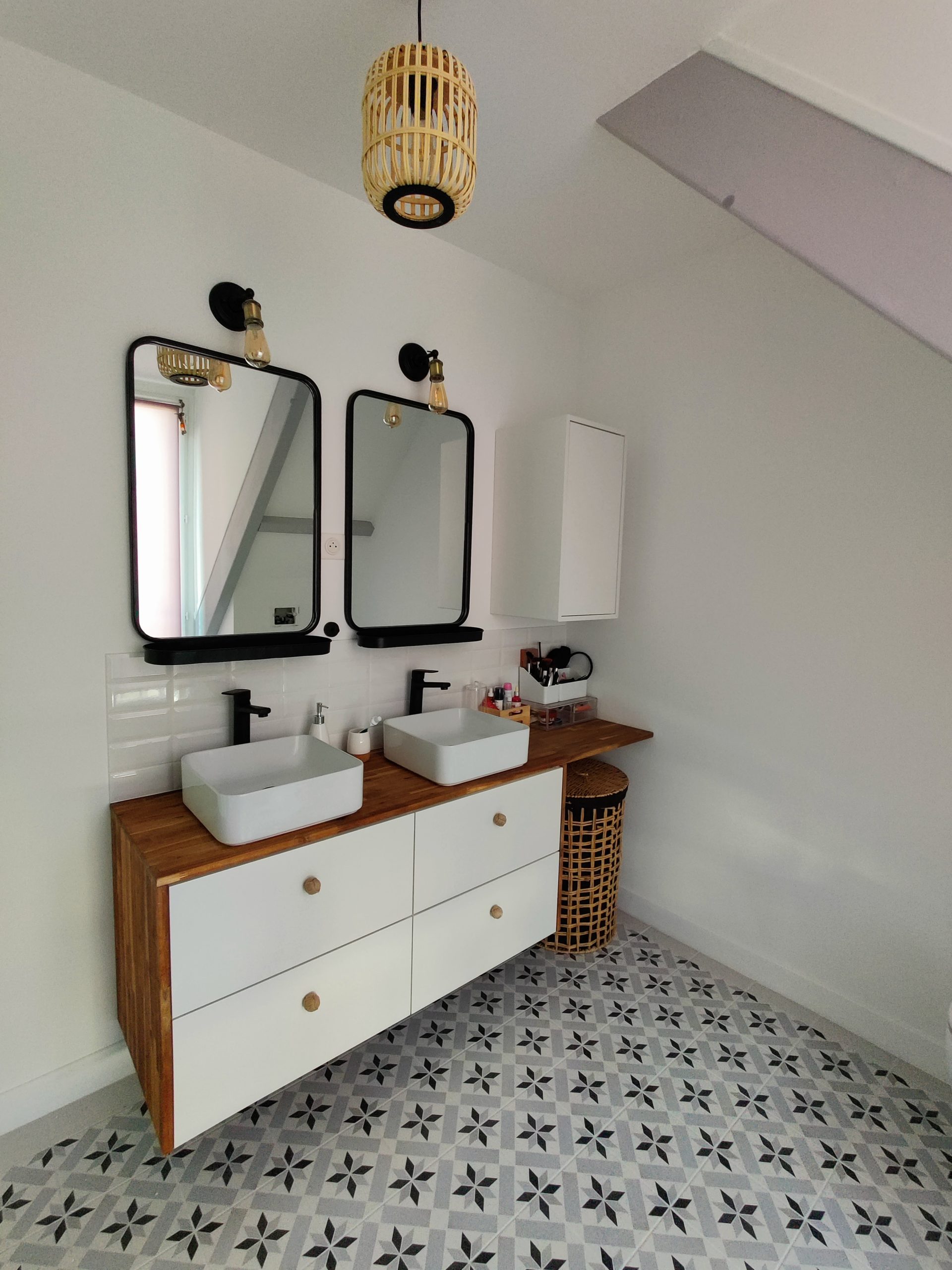 Installation d’un meuble de salle de bains avec deux vasques, deux miroirs et une élégante crédence au sol.