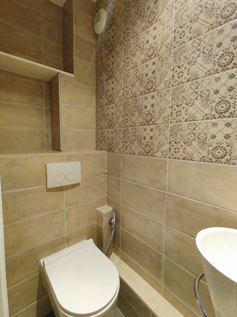 Installation de carreaux muraux dans un espace WC rénové pour un rendu moderne et esthétique.