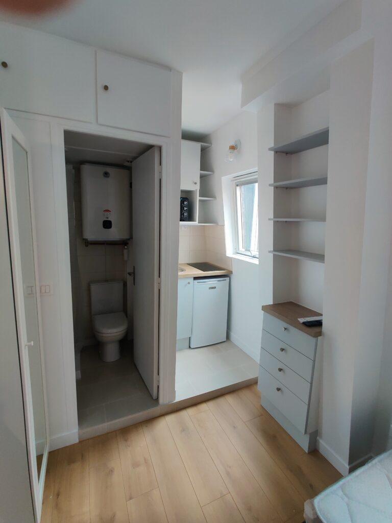 Rénovation complète d’un petit appartement parisien, incluant la pose d’une cuisine et de nouveaux sanitaires.