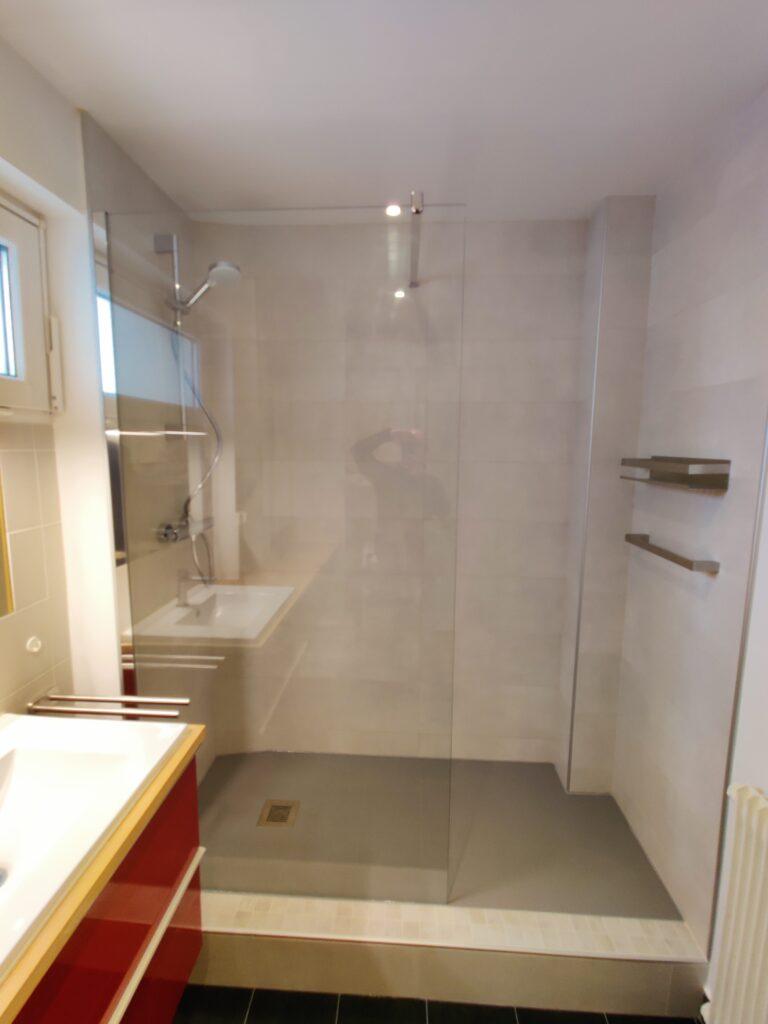 Aménagement d’une douche avec installation d’un receveur de douche extra-plat pour un espace moderne et fonctionnel.