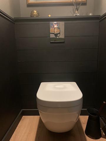 Rénovation complète des WC avec installation d’un WC suspendu et peinture des murs en noir, créant une atmosphère moderne et élégante.