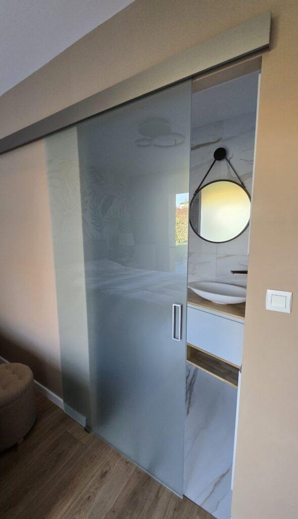 Pose d'une plaque en verre pour créer une séparation avec la salle de douche