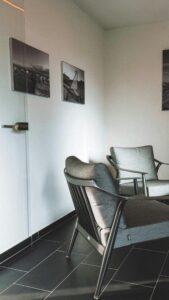 Salle de réunion chez un professionnel avec 2 fauteuils et une porte vitrée