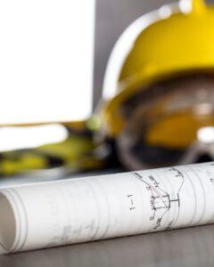Casque de chantier posé sur un plan de travaux – préparation de chantier à Paris