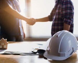 Poignée de main entre un client et un professionnel d’Avinkel Rénovation à Paris – accord de chantier autour d’un plan et d’une maquette