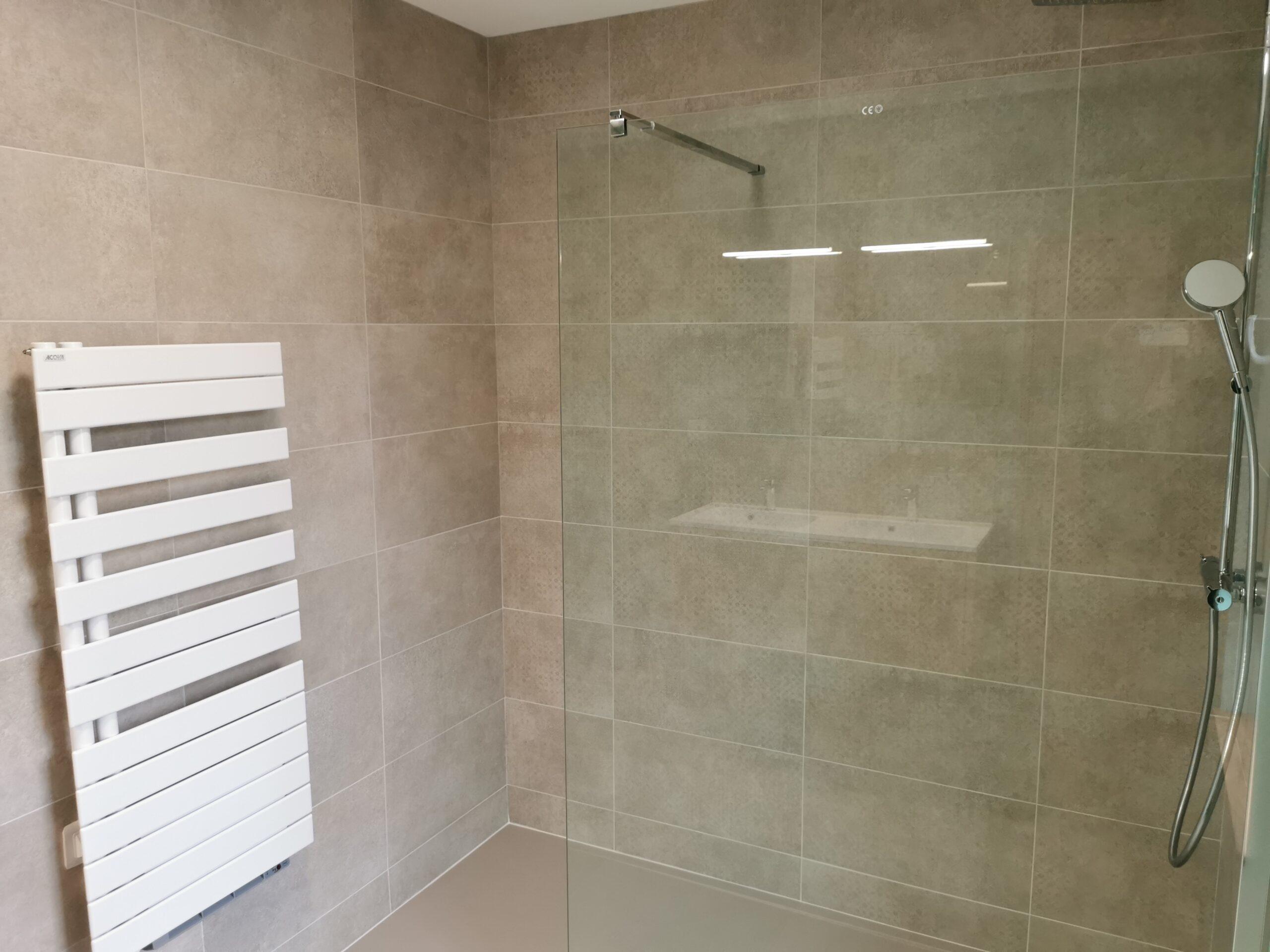 Douche rénovée avec paroi, pommeau et sèche-serviettes installés