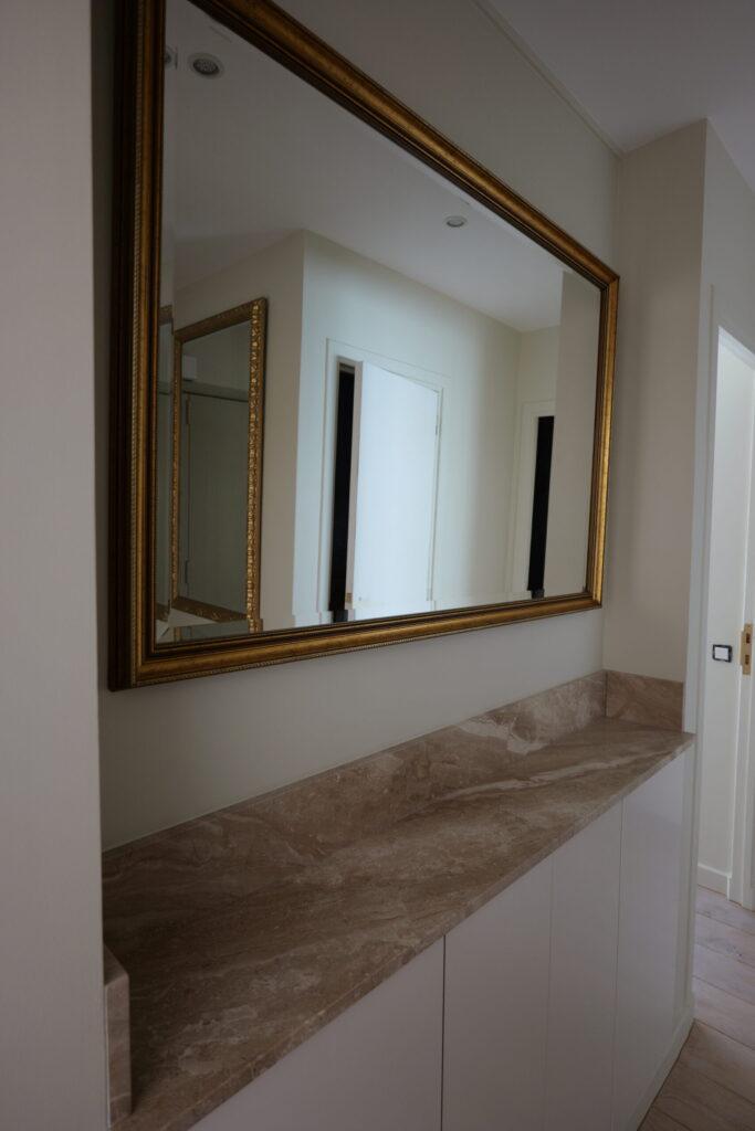 Beau meuble d'entrée blanc avec du marbre et son grand miroir doré