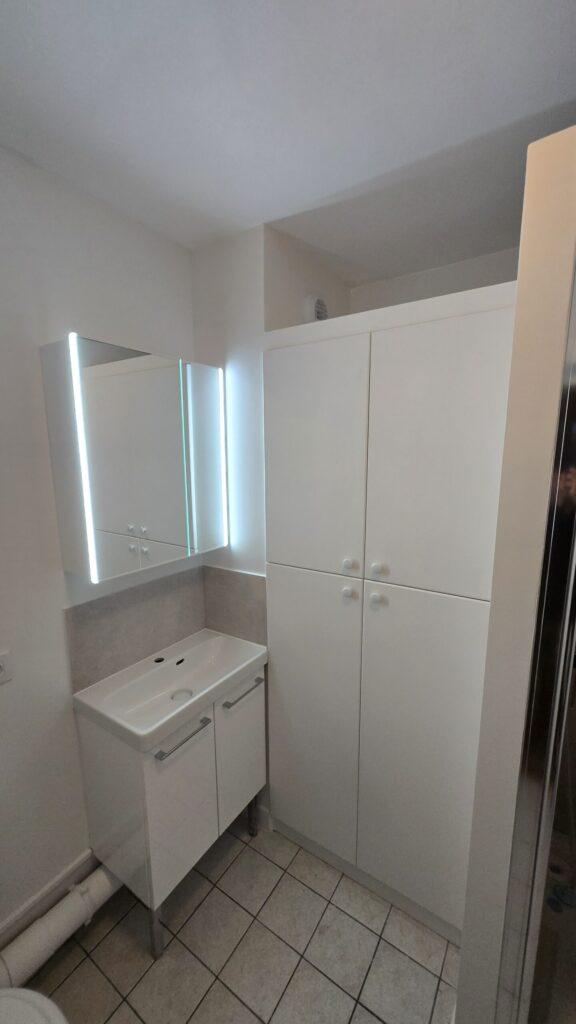 Salle de bain avec armoire à pharmacie, meuble vasque à doubles portes et grande armoire blanche