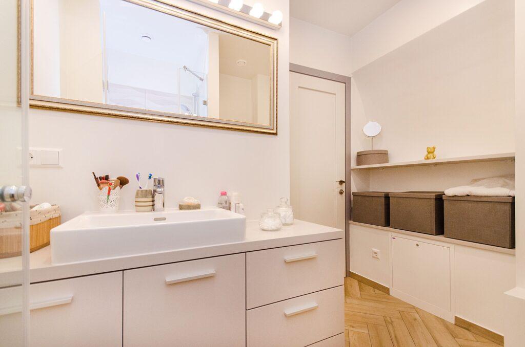 Salle de bain lumineuse avec meuble vasque blanc et rangements intégrés