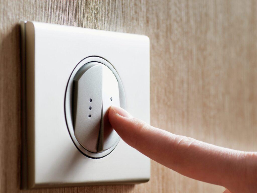 Doigt appuyant sur un interrupteur double bouton au design rond