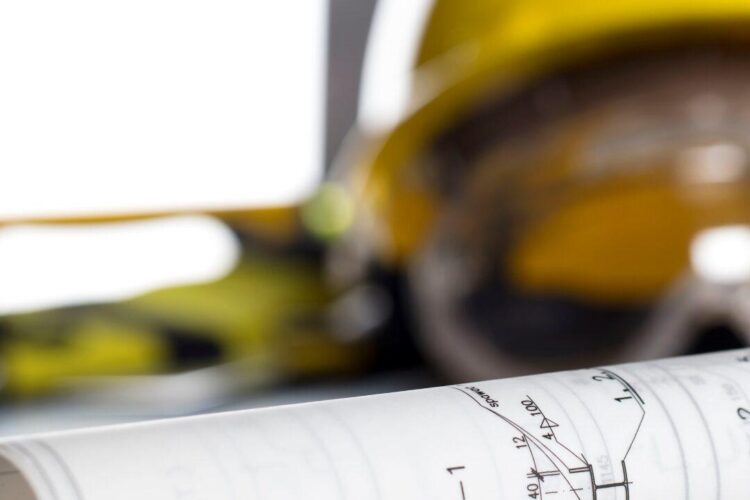 Casque de chantier posé sur un plan de travaux – préparation de chantier à Paris